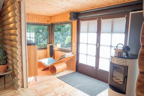 ein Wohnzimmer mit einer Tür und ein Zimmer mit Fenstern in der Unterkunft Ferienhaus Naturliebe in Winterberg
