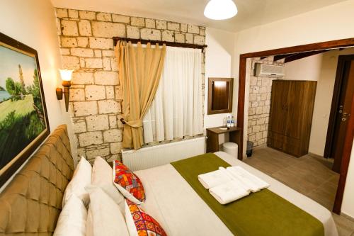 a bedroom with a bed and a stone wall at ZEVKLİLER ALAÇATI hotel in Alaçatı