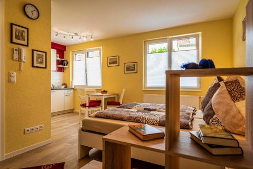 a bedroom with yellow walls and a bed and a table at Im Unterdorf Apartments Rust in Rust