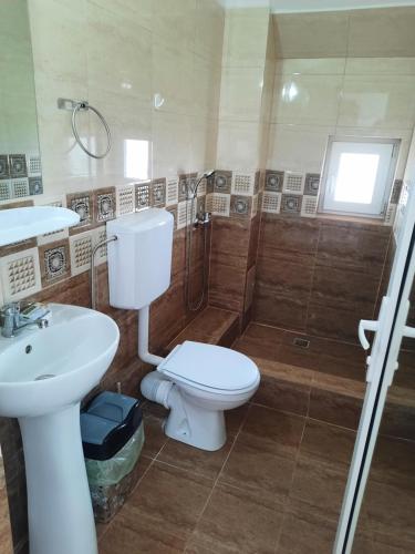 een badkamer met een toilet, een douche en een wastafel bij Casa Benny in Costinesti