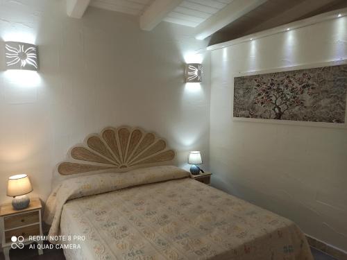 een slaapkamer met een bed met 2 nachtkastjes en 2 lampen bij Bello Bello Rooms in Santa Teresa Gallura