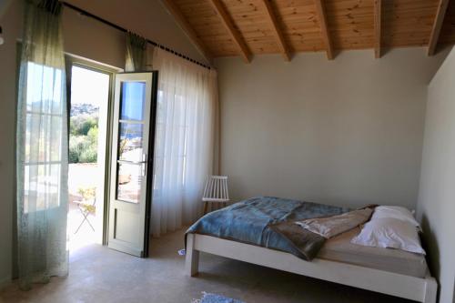 a bedroom with a bed and a sliding glass door at Vanua house in Galatas