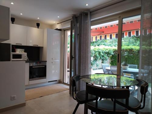 une cuisine et une salle à manger avec une table et des chaises en verre dans l'établissement Golfe Paradis, à Vallauris