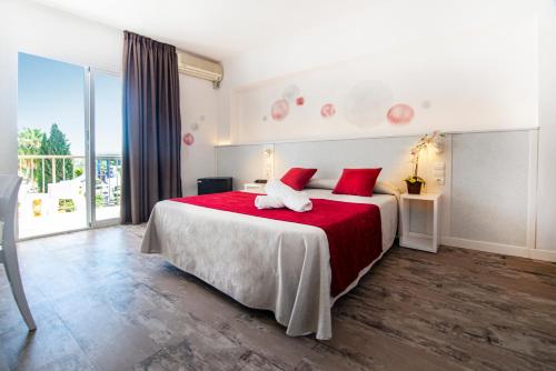 um quarto com uma cama grande e almofadas vermelhas em Hotel Tarba em San Antonio