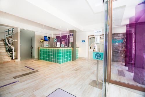 een grote kamer met paarse en groene muren en houten vloeren bij Hotel Tarba in San Antonio