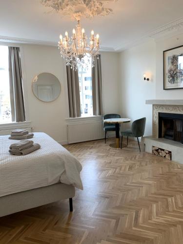 a bedroom with a bed and a fireplace and a chandelier at The Harbour Leiden in Leiden