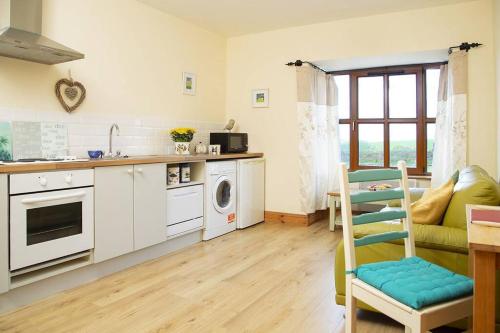 a kitchen with white cabinets and a stove top oven at Apartment on the Wild Atlantic Way in Tralee
