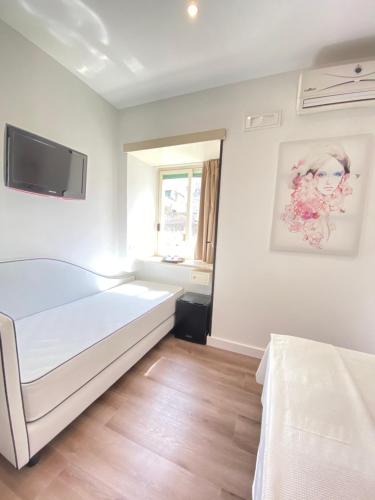 a bedroom with a bed and a tv on the wall at Hotel Europeo Napoli in Naples