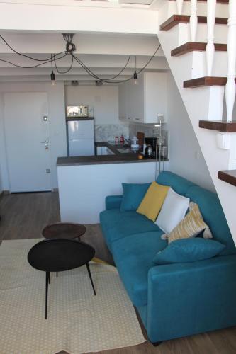 un salon avec un canapé bleu et une cuisine dans l'établissement SUPERBE DUPLEX avec Vue imprenable sur le VIEUX PORT, à Marseille