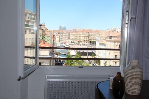 d'une grande fenêtre avec vue sur la ville. dans l'établissement SUPERBE DUPLEX avec Vue imprenable sur le VIEUX PORT, à Marseille