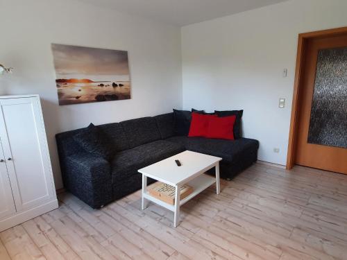a living room with a black couch and a white table at Satow Gartenwohnung in Satow