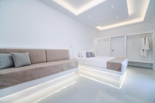 a white room with a couch and a bed at Serenità Luxury Suites in Akrotiri