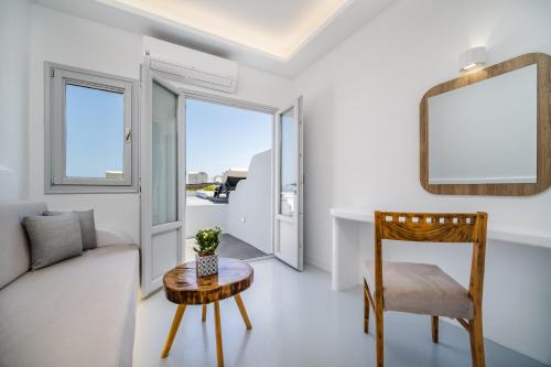 a living room with a couch and a table and a mirror at Serenità Luxury Suites in Akrotiri