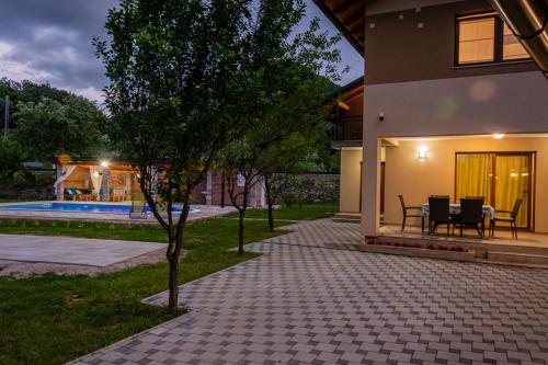 a house with a patio with a tree in the yard at Holiday Home Faruk in Račić