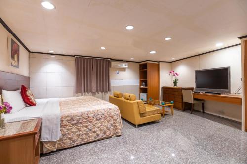 a hotel room with a bed and a desk at Yi Pin Business Hotel in Taoyuan