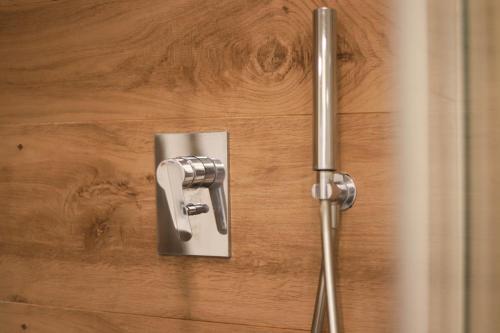 metalowa klamka na drewnianych drzwiach z prysznicem w obiekcie A casa di Carlotta vista mare w mieście Monopoli