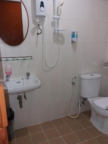 a bathroom with a shower and a toilet and a sink at Hotel Rumah Shinta in Jakarta