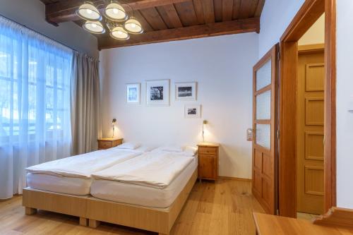 a bedroom with a bed and a large window at Hotel a restaurace U Vychopňů in Vsetín