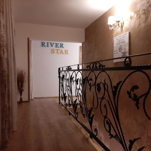 a hallway with a iron railing and a sign on the wall at River Star in Sîngeorgiu de Pădure