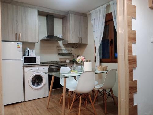 - une cuisine avec une table et des appareils électroménagers blancs dans l'établissement Apartamento playa, à La Corogne