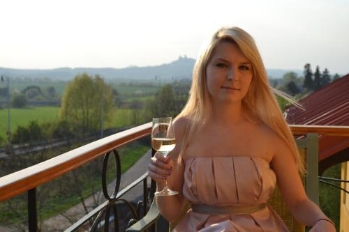 une femme en robe tenant un verre de vin dans l'établissement U Zlate Brany Cesky raj, à Libuň