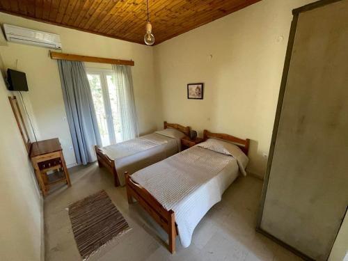 a bedroom with two beds and a window at Petros Studios in Moraitika