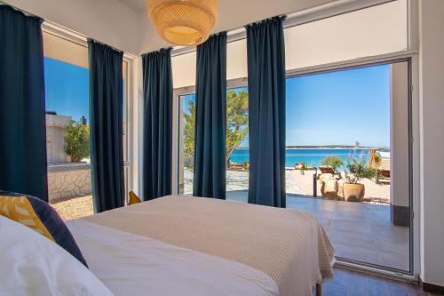 Beachfront Paladina holiday home في كولان: غرفة نوم مع سرير وإطلالة على المحيط