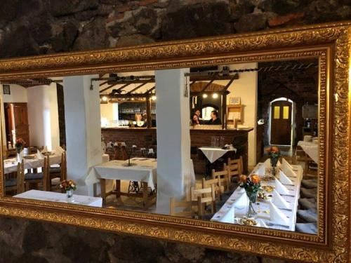 a mirror reflecting a dining room with tables and chairs at Schwarzenberský panský dvůr in Čimelice