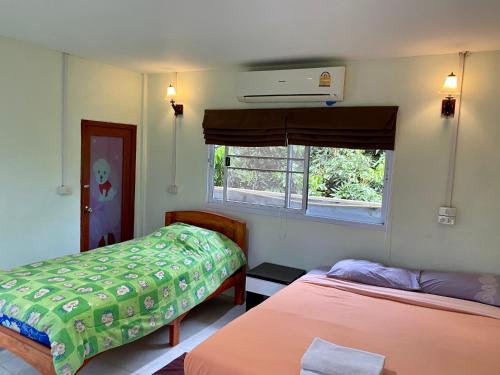 a room with two beds and a window at Huen Vasana Chiang Dao in Chiang Dao
