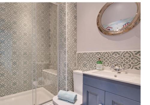 uma casa de banho com um lavatório, um espelho e uma banheira em Silverwood Apartment, Whitby em Whitby