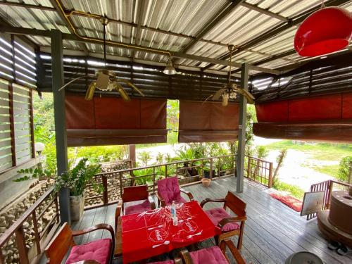 a table and chairs on a deck with a red table and chairs at Huen Vasana Chiang Dao in Chiang Dao