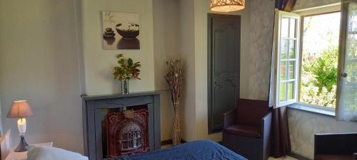 Sassetot-le-MauconduitにあるLa Ferme aux Canardsの暖炉、ベッド、窓が備わる客室です。