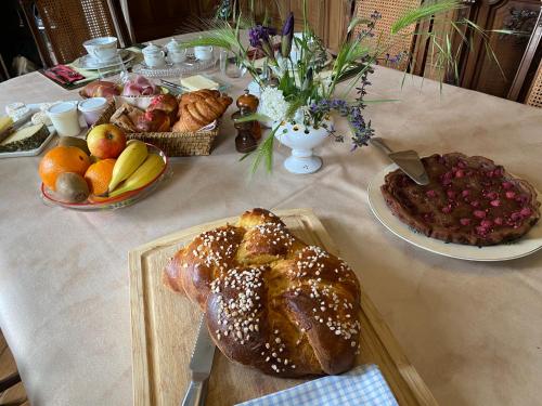 a table with a loaf of bread and a plate of fruit at Castel serein in Maubec