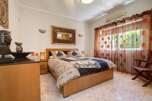 a bedroom with a bed and a table and a window at VILLA DOMIPAJO in Carvoeiro