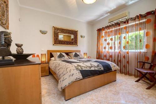 1 dormitorio con cama, mesa y ventana en VILLA DOMIPAJO, en Carvoeiro