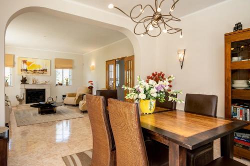 a dining room with a table and chairs with a vase of flowers at VILLA DOMIPAJO in Carvoeiro