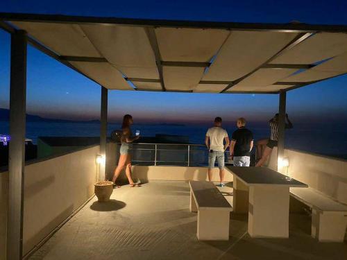 a group of people standing on top of a balcony at Almyra Apartments & Suites in Sfakaki