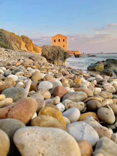 a large pile of rocks on a beach at B&B Le Sorelle in San Leone