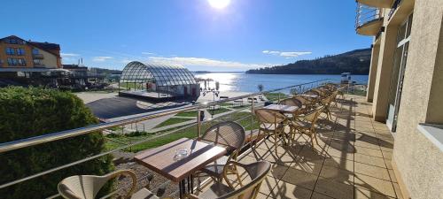 a balcony with chairs and a view of the water at Port Club pension & restaurant in N&aacute;mestovo
