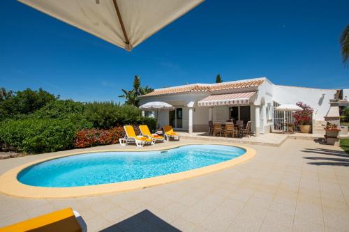 a swimming pool in front of a house at VILLA DOMIPAJO in Carvoeiro