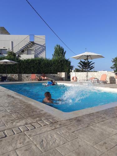 a person swimming in a swimming pool at Almyra Apartments & Suites in Sfakaki