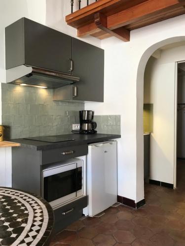 une cuisine avec une cuisinière et un micro-ondes dans l'établissement Maison de pêcheur à Porquerolles, à Porquerolles