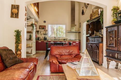 a living room with a leather couch and a table at Roofless Surf Lodge in Soorts-Hossegor