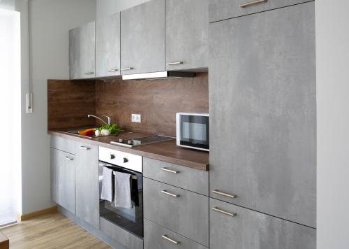a kitchen with stainless steel cabinets and a microwave at ZeitRaum in Burgbernheim