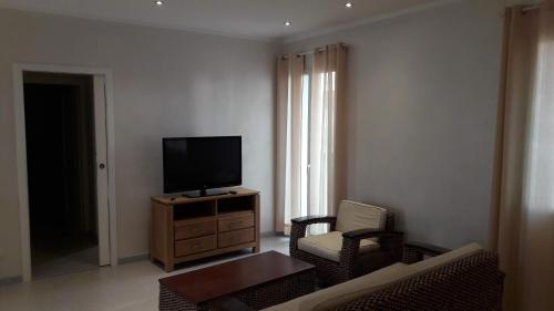 a living room with a tv on a wooden dresser at La casa di Pier in Olbia