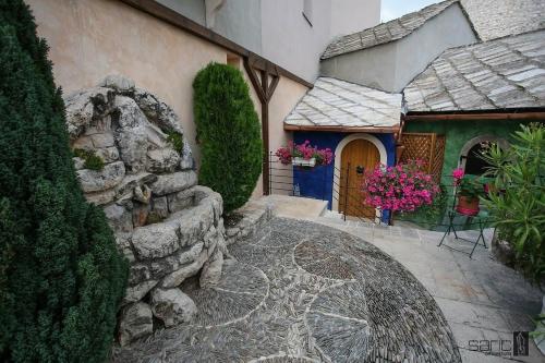 ein Haus mit einer Steinmauer und einer Tür mit Blumen in der Unterkunft Ali Baba Apartment in Mostar