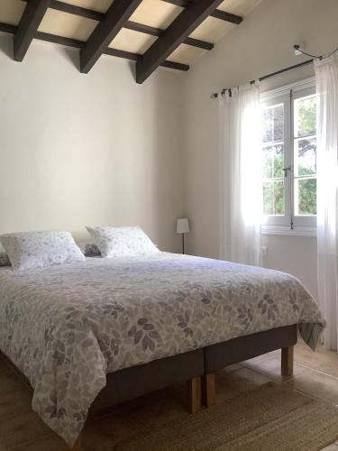 a bedroom with a bed with a white comforter and a window at FONOLL MARÍ in Cala en Forcat