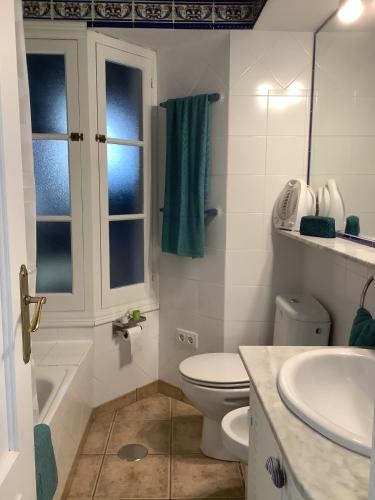 a white bathroom with a toilet and a sink at FONOLL MARÍ in Cala en Forcat