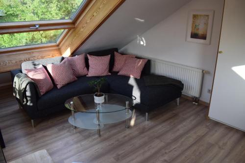a living room with a black couch and a glass table at Ferienwohnung Ahrtalblick in Sinzig