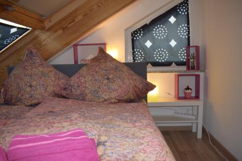 een slaapkamer met een bed met roze lakens en kussens bij Ferienwohnung Ahrtalblick in Sinzig